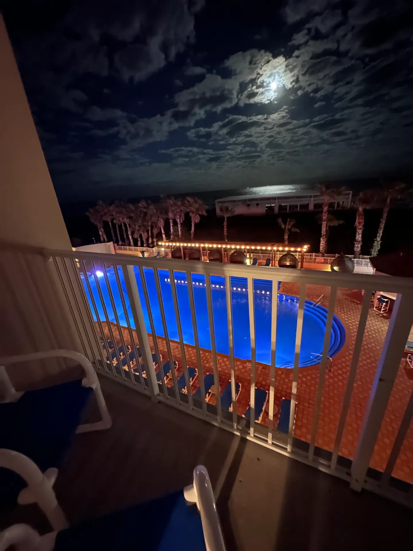 The hotel pool lit up at night under a full moon at South Padre Island, Texas