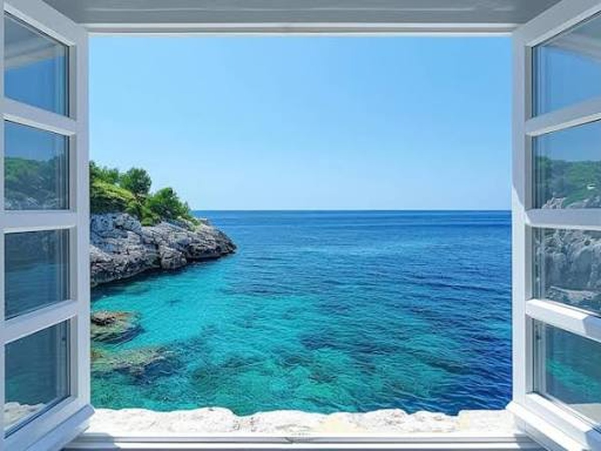 Open window looking over a turquoise sea cove
