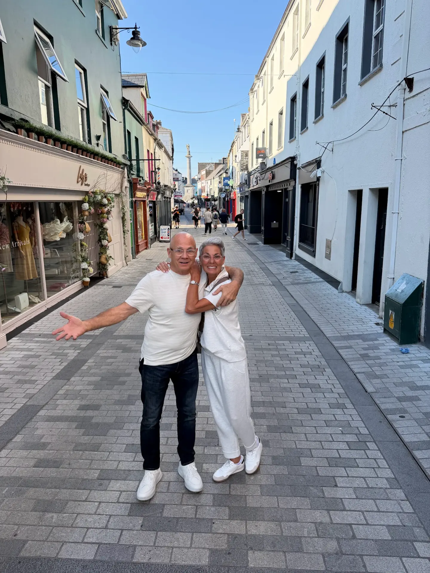 Robin and her husband on a colorful street in an Irish town