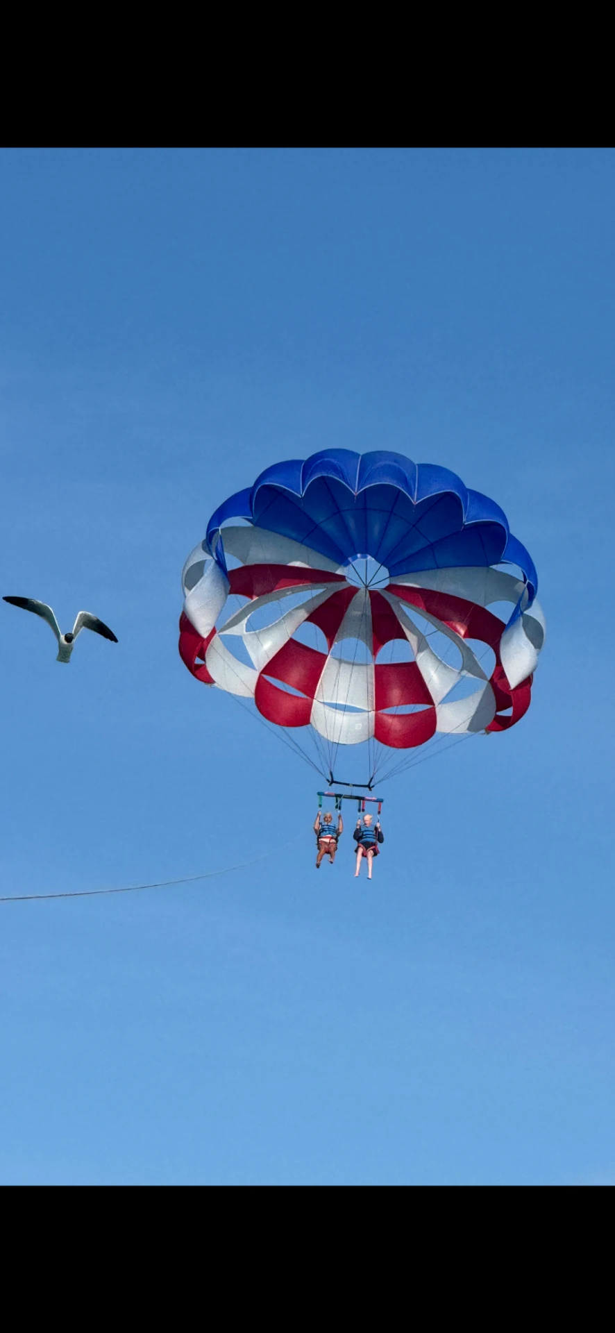Gary and his wife parasailing over South Padre Island, Texas, on a winter getaway planned by Paradise Travel