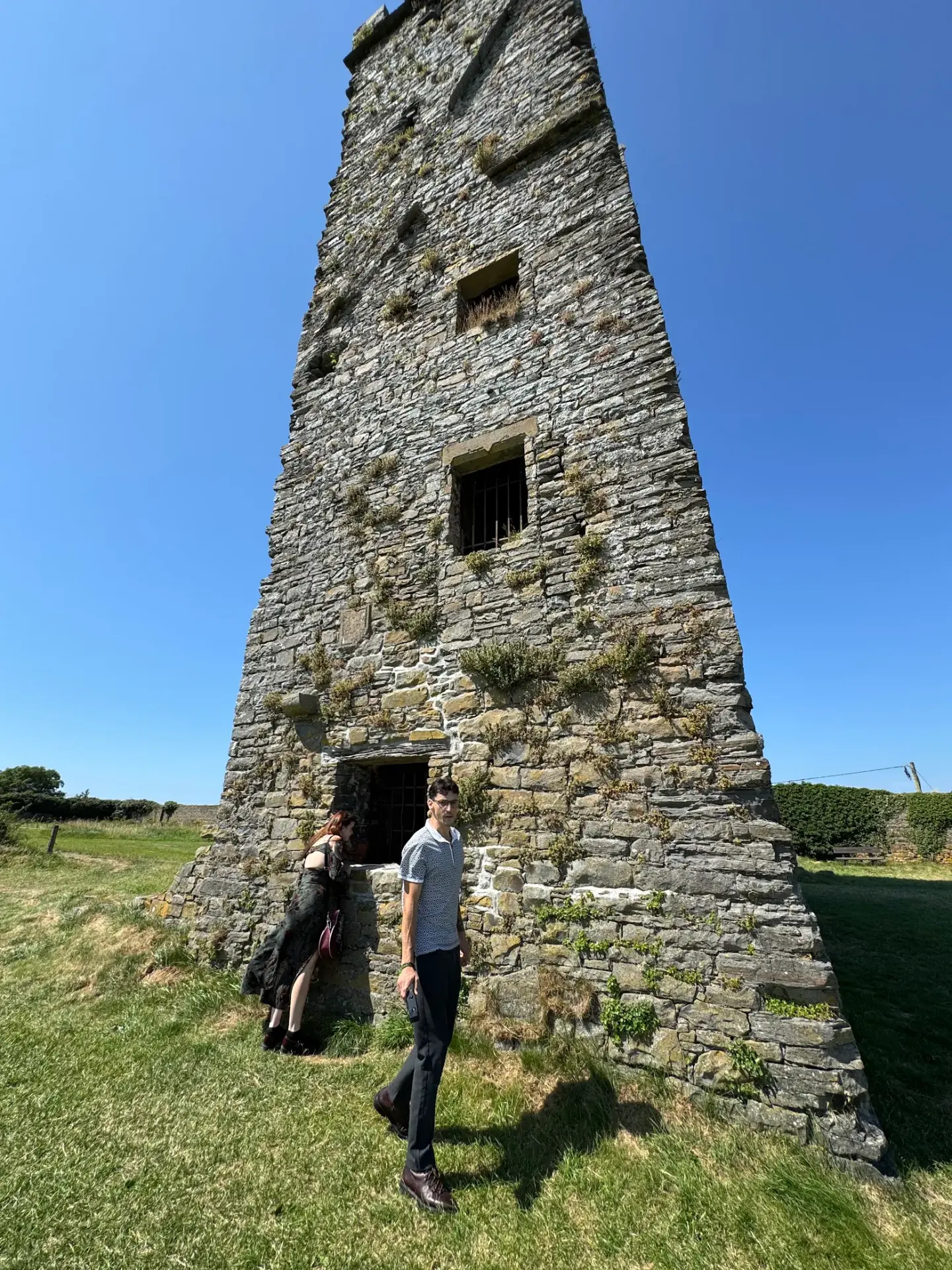 Riccardo and his wife at a stone tower on the Irish coast