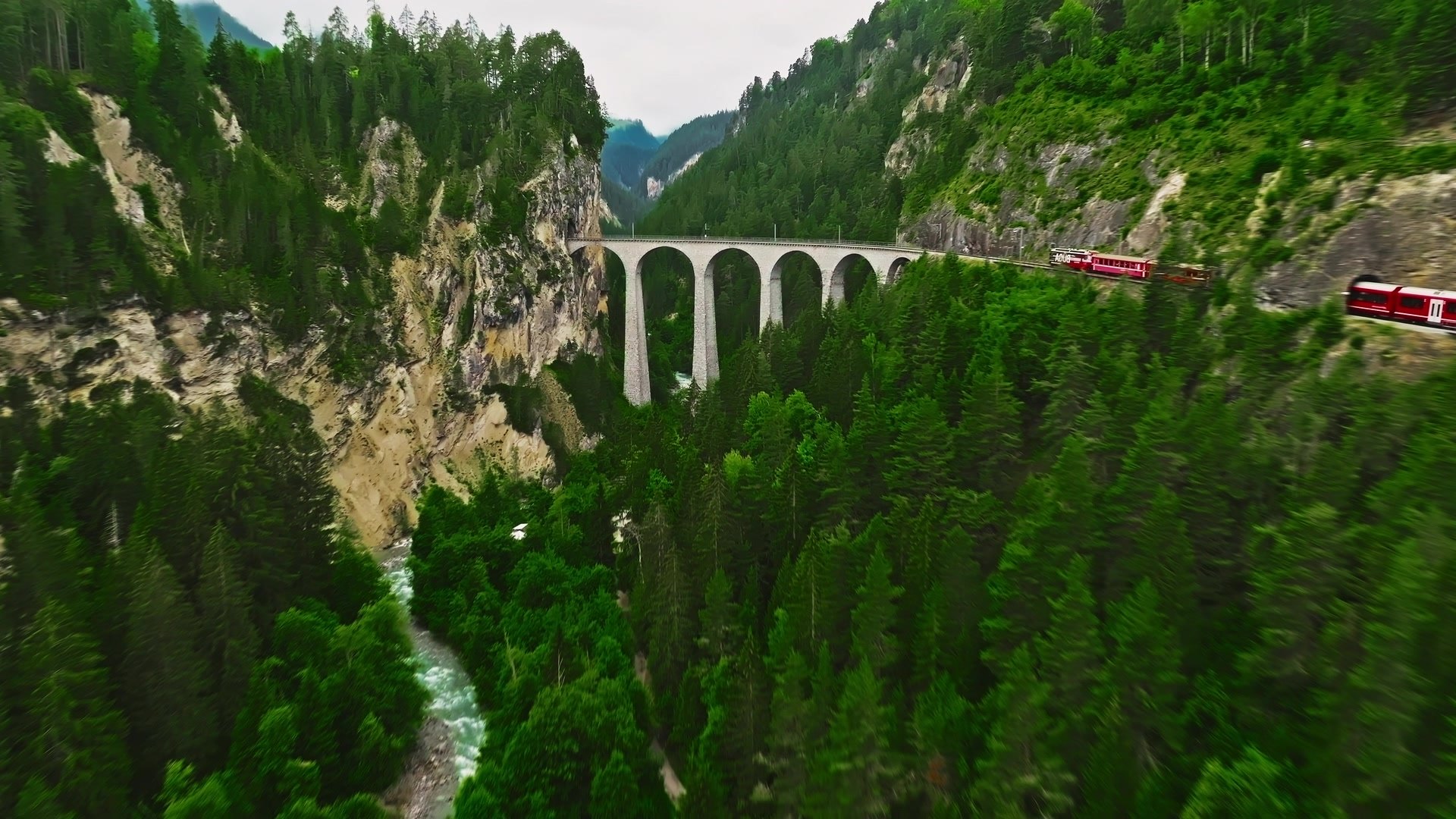 Red train crossing the Landwasser Viaduct in the Swiss Alps
