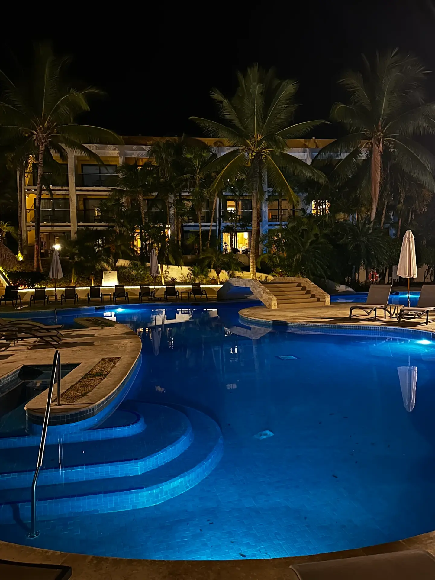 The resort pool lit up at night in Cozumel, Mexico